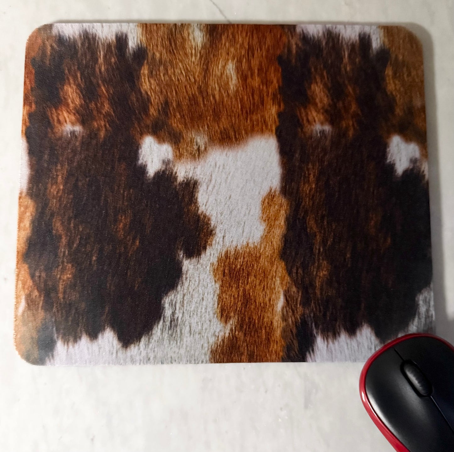 Mouse pad with cow print pattern .