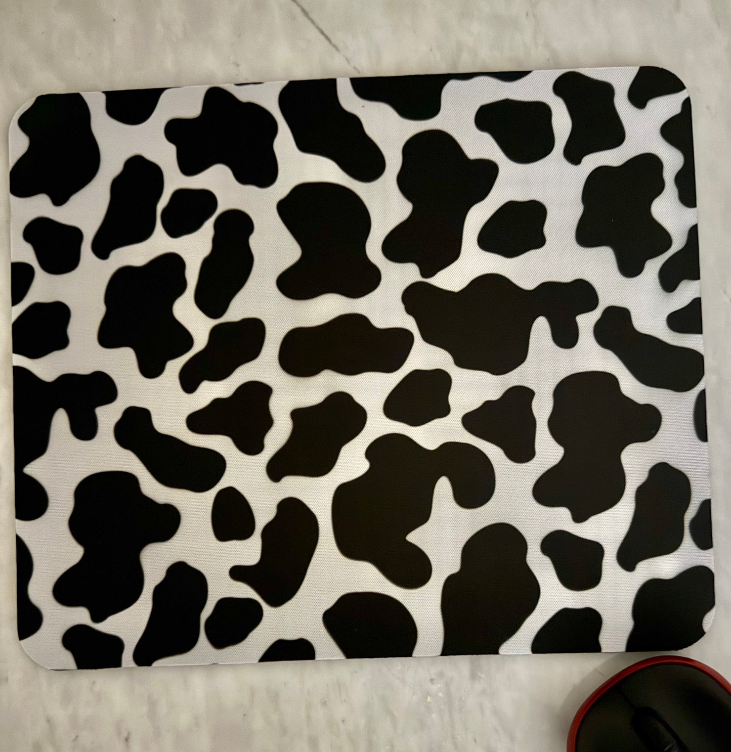 Black and white cow print mouse pad .